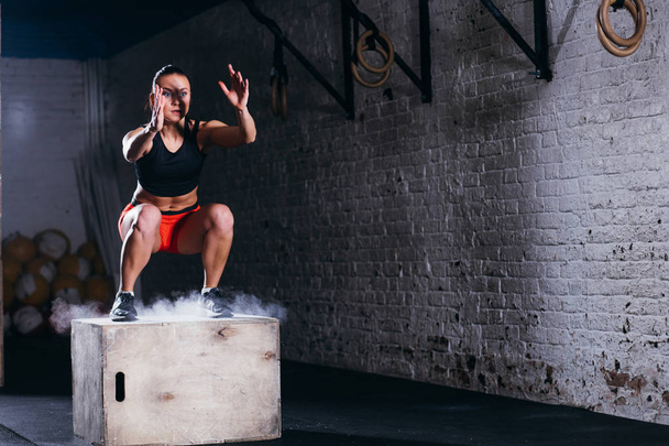woman jumping box. Fitness woman doing box jump workout at cross fit gym. - Photo, image