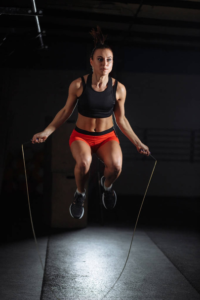 woman Exercises with Jump or Skipping Rope in Gym - 写真・画像