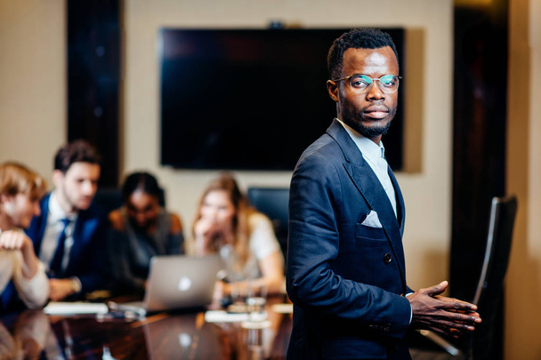 african businessman looking on camera with group of businesspeople on background - Fotoğraf, Görsel