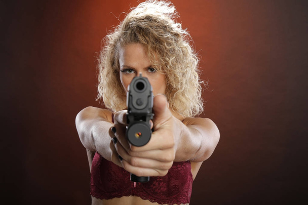 Fit blonde carries a semi-automatic pistol - Fotó, kép
