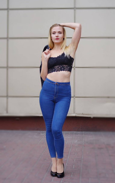 Bella ragazza in posa in jeans blu e crop top nero
 - Foto, immagini