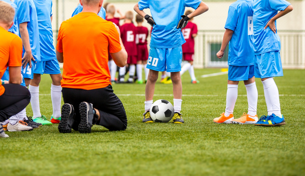 Αγόρια με προπονητή ποδοσφαίρου έχοντας ενθαρρυντικής ομιλίας πριν νεολαία αθλητικά τουρνουά ανταγωνισμού - Φωτογραφία, εικόνα