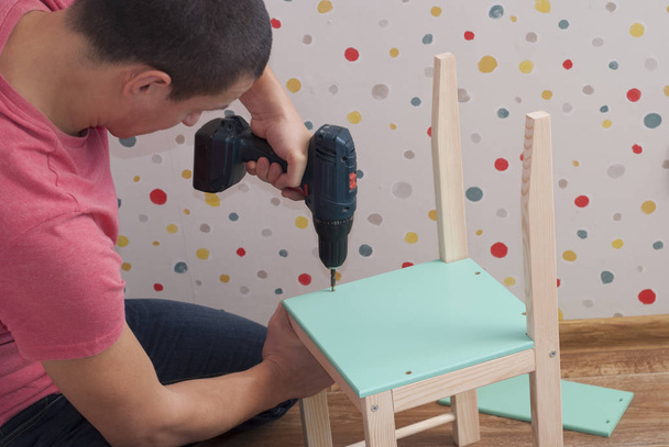father assembles a chair for children - Photo, image