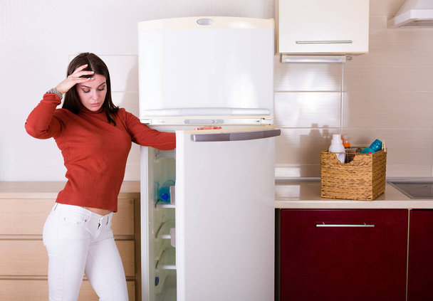 schöne junge Frau putzt ihre Wohnküche - Foto, Bild