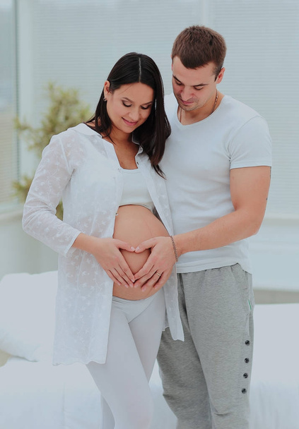 man and woman illustrayte the heart on her baby bump by hands. - Zdjęcie, obraz