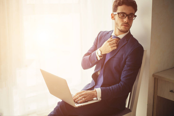 finance market analyst in eyeglasses working at sunny office on laptop - Foto, Bild