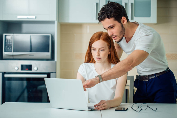 couple with laptop spending time together at home, man pointing at screen - Foto, Imagem