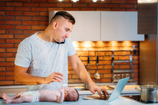 Man working from home and taking care of baby - Foto, Bild