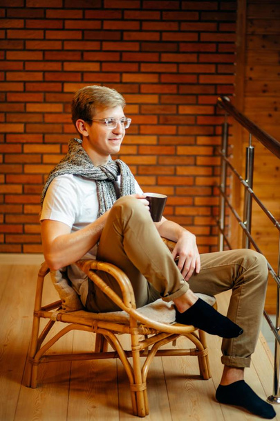 man resting in armchair with cup of coffee - Fotó, kép