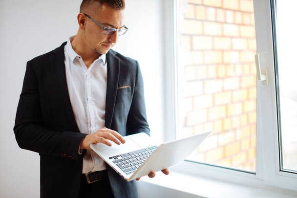 handsome man wearing glasses working with laptop in office - Φωτογραφία, εικόνα