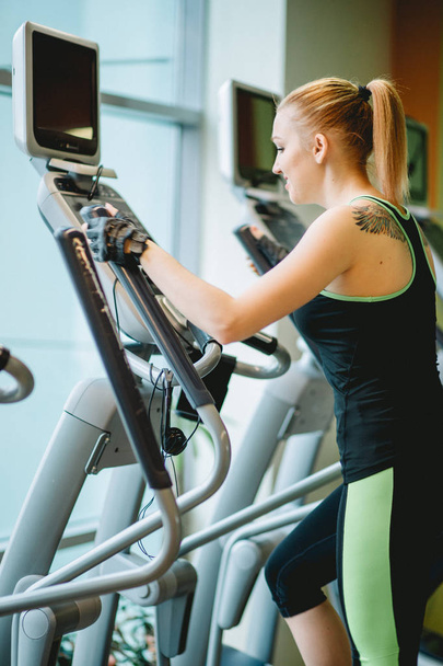 woman exercising on cross trainer machines. - Fotó, kép