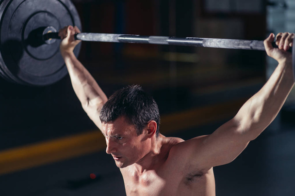 fitness man lifting heavy barbell at gym - Photo, Image