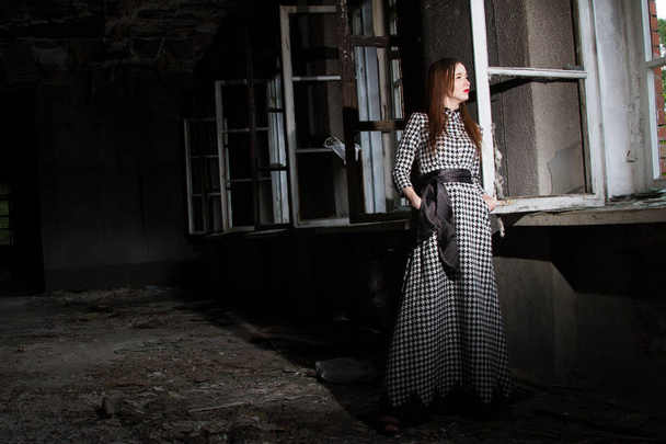 lány egy elhagyott házban az ablak áll - Fotó, kép