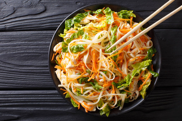 Vietnamese chicken salad with rice noodles, carrots and herbs ma - Foto, afbeelding