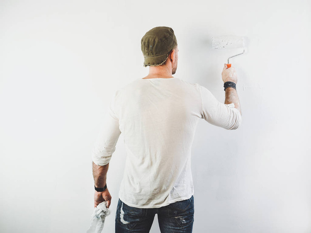 young guy painting a wall in the house - Foto, Bild