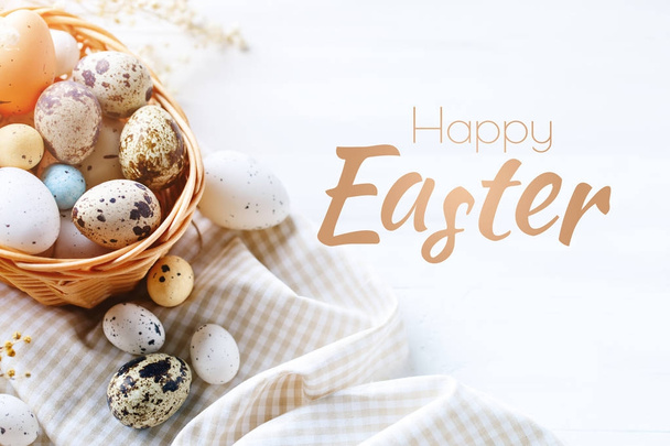 Happy Easter. Congratulatory easter background. Easter and quail eggs on a wooden table. - Fotografie, Obrázek