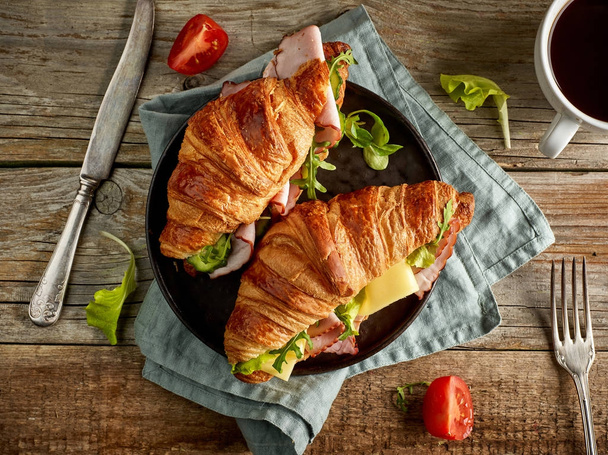 two croissant sandwiches on wooden table - Фото, изображение