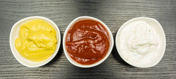 Salsas de colores. Salsa de ajo, ketchup y mostaza. Vista desde arriba
. - Foto, imagen