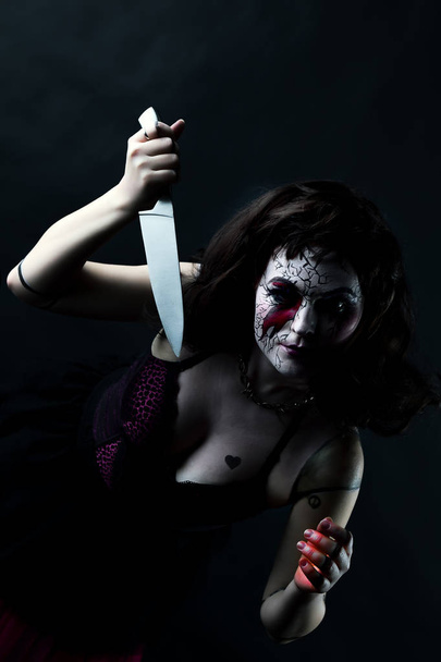 model with makeup scary doll with knife - Photo, image