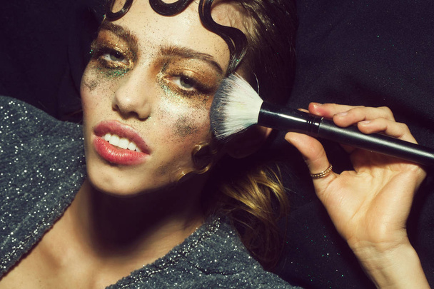 Pretty fashion girl putting holiday glitter makeup - Fotó, kép