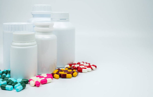 Αντιβιοτικό κάψουλες χάπια και πλαστικό μπουκάλι με κενή ετικέτα που απομονώνονται σε λευκό φόντο με αντίγραφο χώρου. Ναρκωτικών αντίσταση έννοια. Χρήση ναρκωτικών αντιβιοτικά με λογικές και καθολική αντίληψη υγειονομικής περίθαλψης. - Φωτογραφία, εικόνα