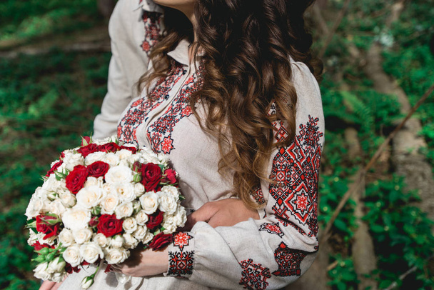 bruid Houd in de hand bruiloft boeket biege en rode rozen. - Foto, afbeelding
