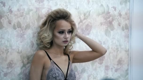 Jonge blonde model in het ondergoed poseren voor de fotograaf tijdens fashion fotosessie - Video