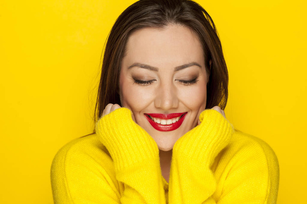 Beautiful sexy woman in yellow blouse on a yellow background - Photo, Image