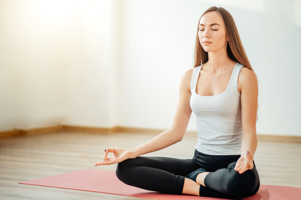 Молодая женщина медитирует во время занятий йогой
 - Фото, изображение