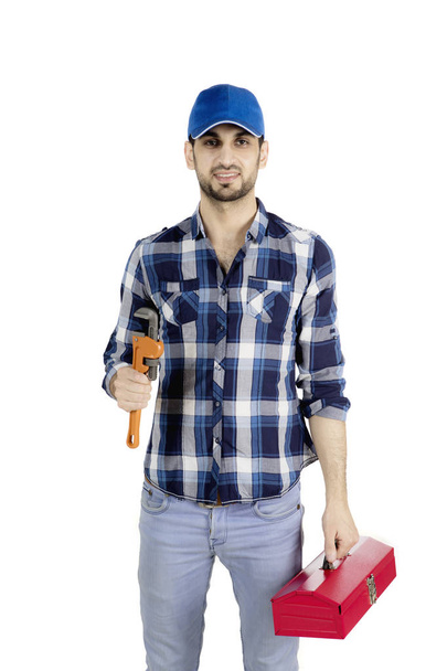 Male plumber carrying tool box on studio - Photo, image