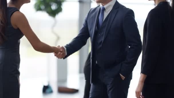 4K Portrait of smiling businessman shaking hands with clients at end of meeting - Metraje, vídeo