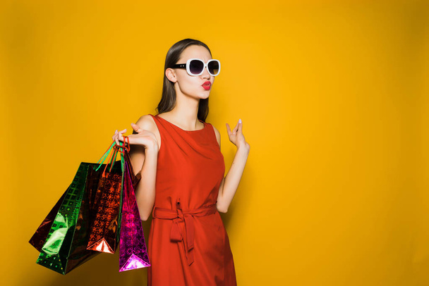stylish young girl shopaholic in red dress and sunglasses loves black Friday - Фото, изображение
