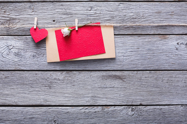 День Святого Валентина, бумажное сердце и открытка на деревянном фоне
 - Фото, изображение
