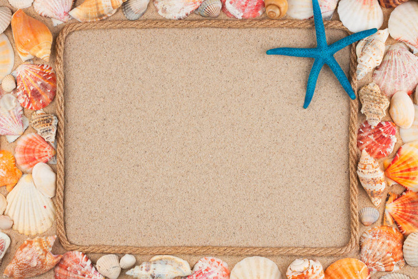 Beautiful frame made of rope and star, sea shells on the sand, with place for your image, text. - Zdjęcie, obraz