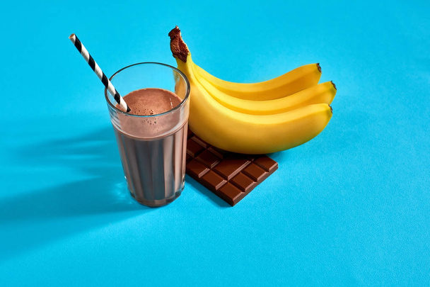 Frullato di banana con cioccolato su sfondo blu
 - Foto, immagini