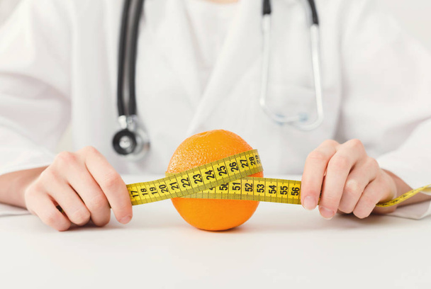 Nutritionniste médecin avec des fruits et ruban à mesurer
 - Photo, image