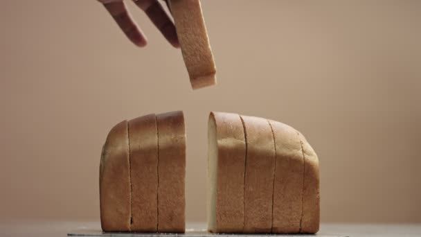 Männerhand legt eine Scheibe Brot vom Ziegelbrot zurück - Filmmaterial, Video
