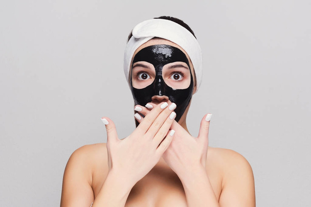 Молода дівчина з маскою для очищення чорного обличчя
 - Фото, зображення