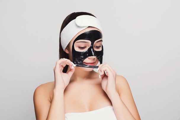 Jeune fille avec masque visage noir purifiant
 - Photo, image