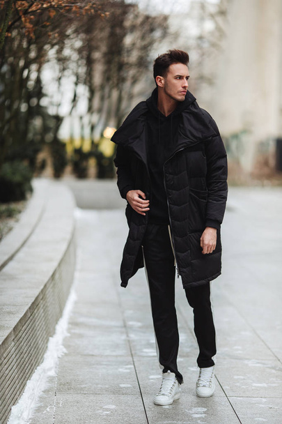 Stylish man wolk on the street. Winter cold outfit. Big jacket w - Zdjęcie, obraz