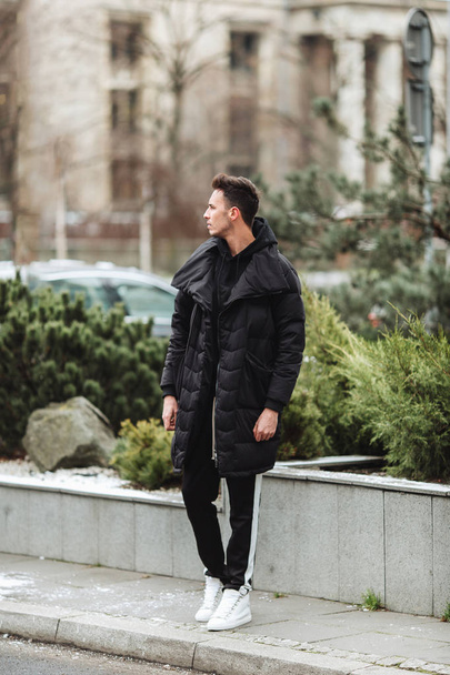 Stylish man wolk on the street. Winter cold outfit. Big jacket w - Foto, Imagen