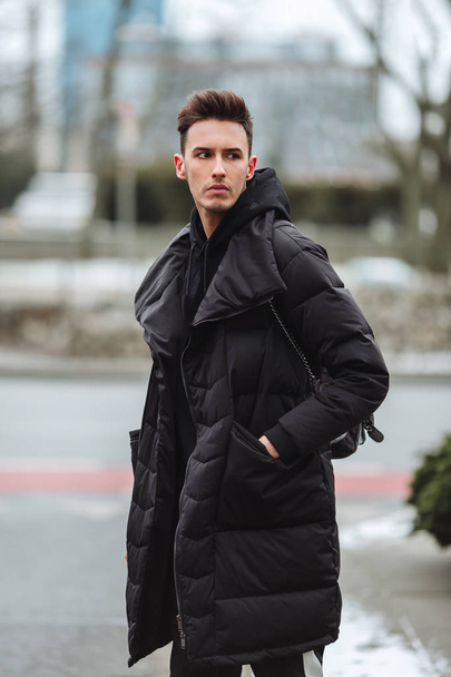 Stylish man wolk on the street. Winter cold outfit. Big jacket w - Foto, afbeelding