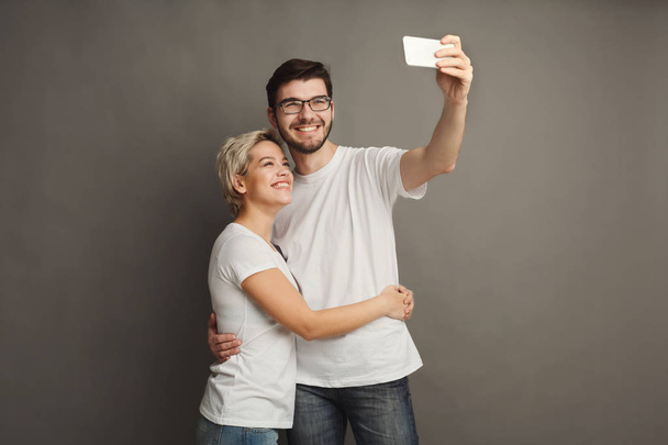 Happy couple taking selfie on smartphone - Фото, зображення