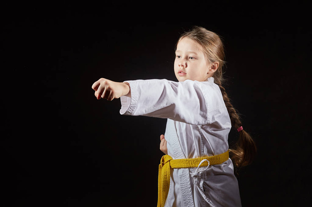 Girl athlete is beating blow hand on a black background - Photo, Image