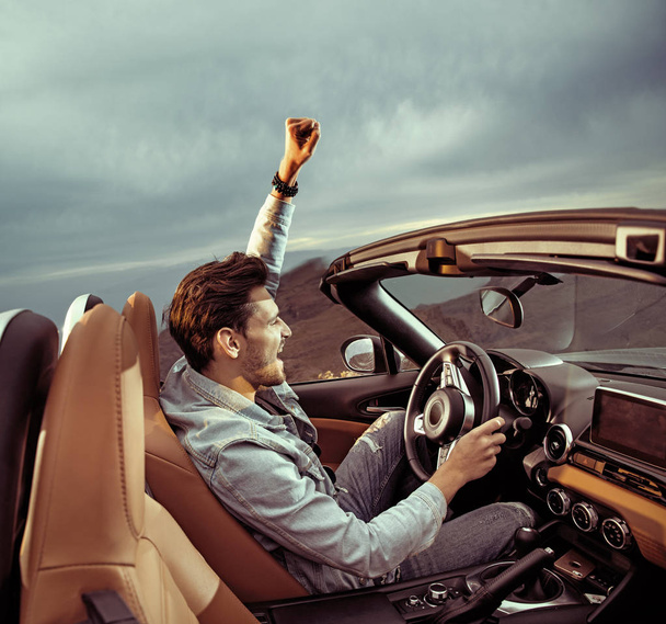 Handsome man riding a luxuriois convertible car - Foto, Imagen
