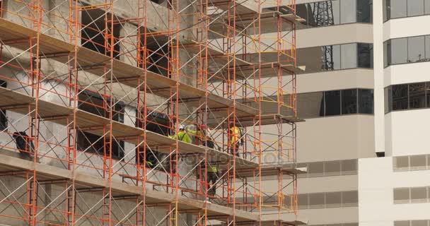 Trabajadores de la construcción en andamios en la ciudad
 - Metraje, vídeo