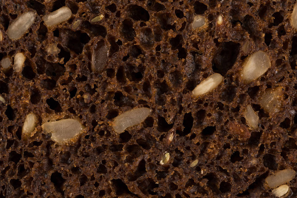 Dark rye bread with sunflower seeds closeup for background - Foto, afbeelding