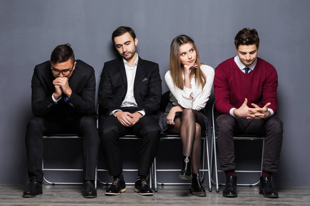 La gente de negocios se aburre mientras está sentada en la silla esperando una entrevista de trabajo en la oficina
 - Foto, Imagen