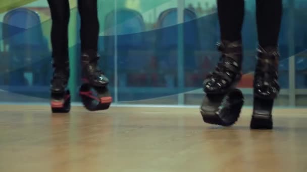 Four people jumping in kangoo shoes in the gym. - Footage, Video