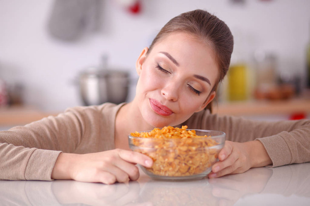Smiling attractive woman having breakfast in kitchen interior. Smiling attractive woman. - Фото, зображення